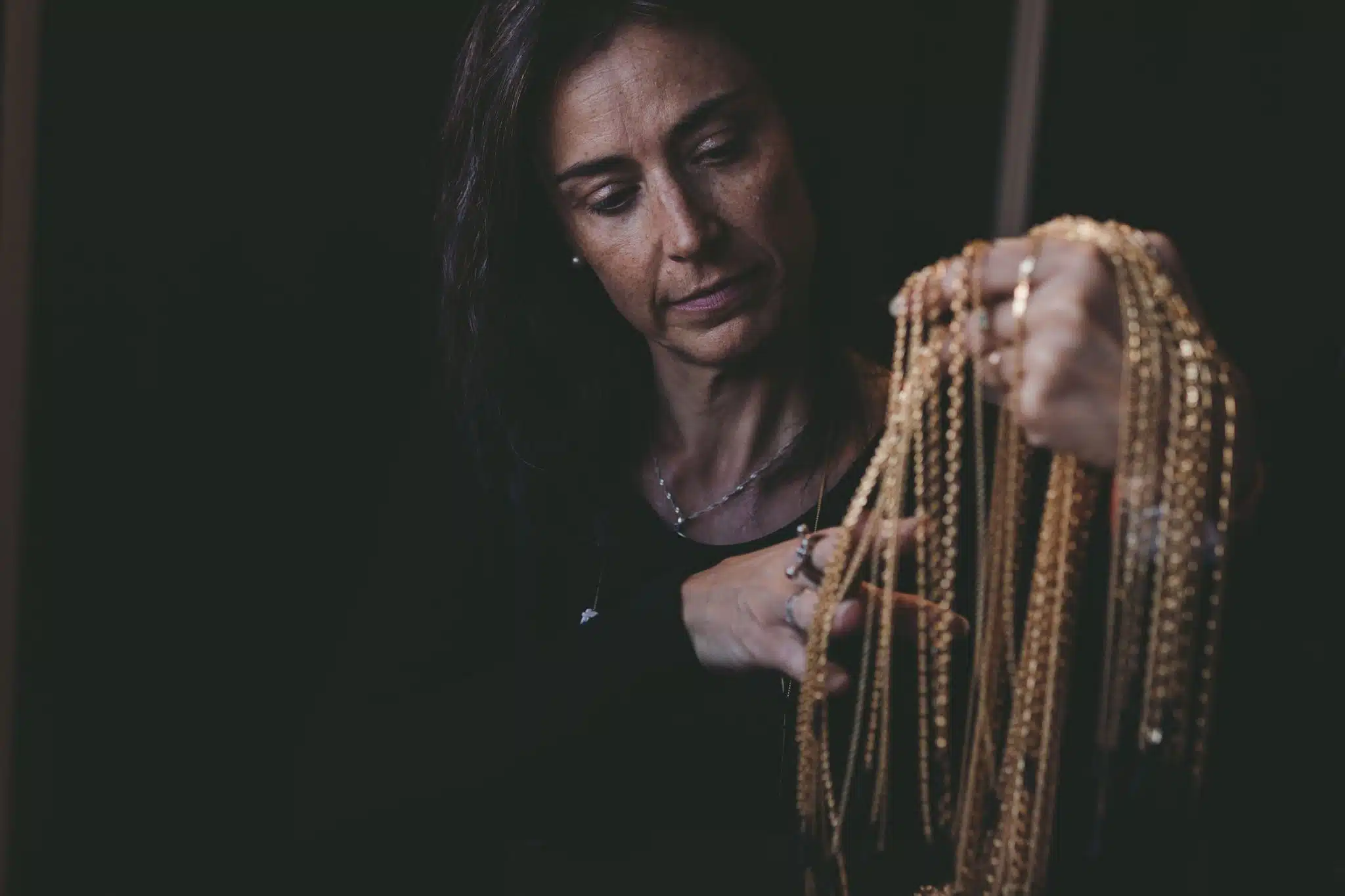 Mireille, la créatrice, nous montre les chaînes dorées qu'elle utilise.