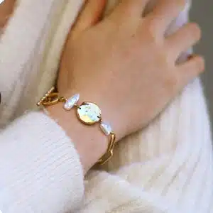 Bracelet acier inoxydable, fermoir anneau et tige avec perle acier inoxydable doré et perles imitation perles de culture. 18 cm.