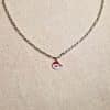 Collier, chaine métal argenté avec pendentif père noël, couleurs rouge et blanc avec zirconium en guise de pompon sur le bonnet du Père Noël.