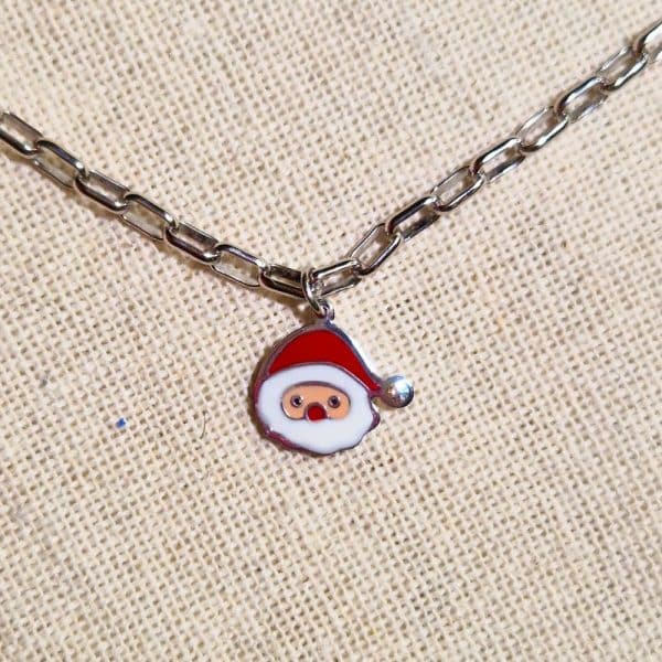 Zoom de la breloque du collier avec pendentif père noël, couleurs rouge et blanc avec zirconium en guise de pompon sur le bonnet du Père Noël.
