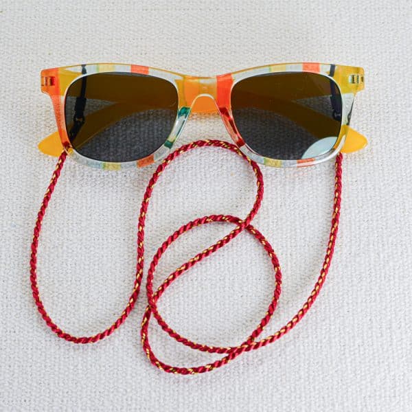 Cordon de lunettes en viscose rouge tressée agrémenté d'un fil doré en lurex doré